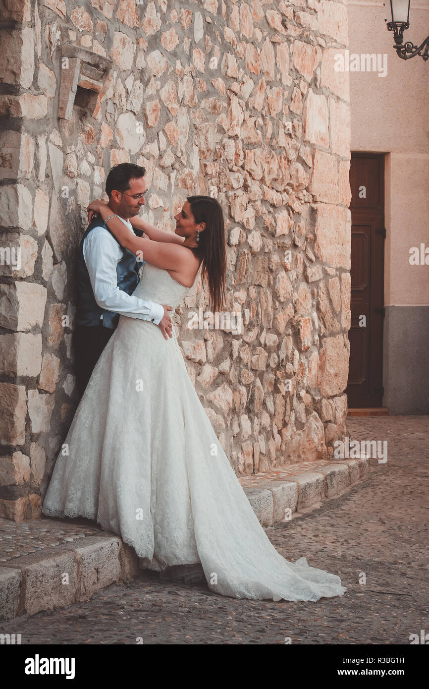 Bride and groom kissing in the street in a mediterranean village Stock ...