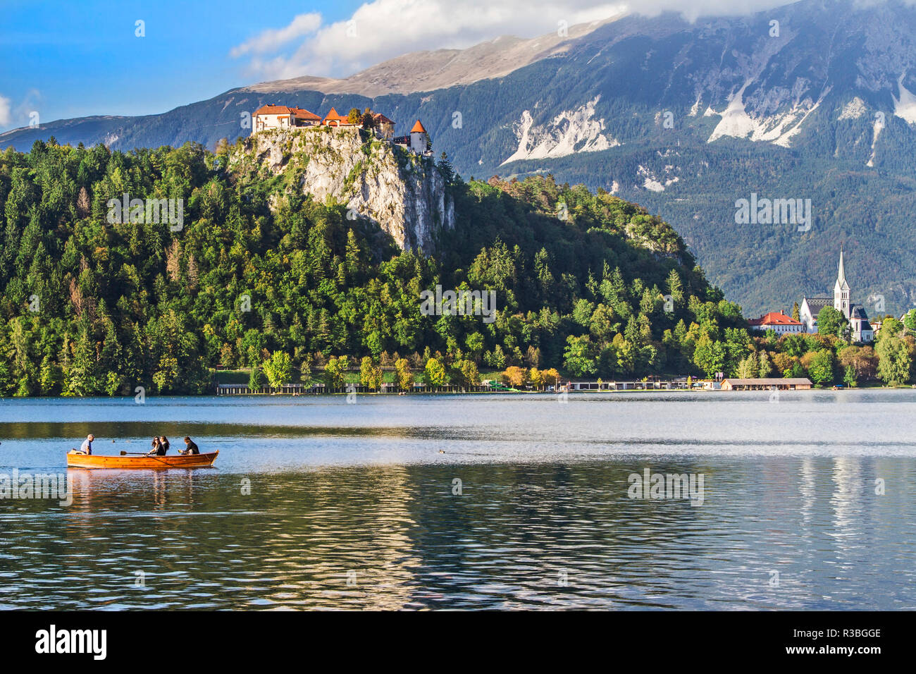 Traditional wooden pletnja rowing boat to ferry tourists to St. Mary's Church of Assumption on the island beyond, Lake Bled, Slovenia Stock Photo
