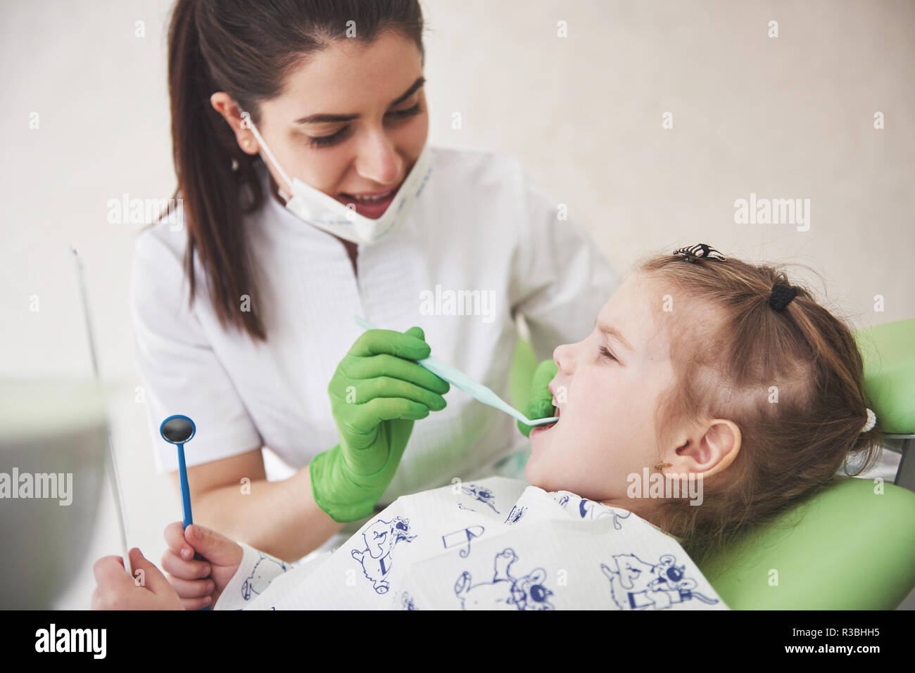 Teeth checkup at dentist's office. Dentist examining girls teeth in the
