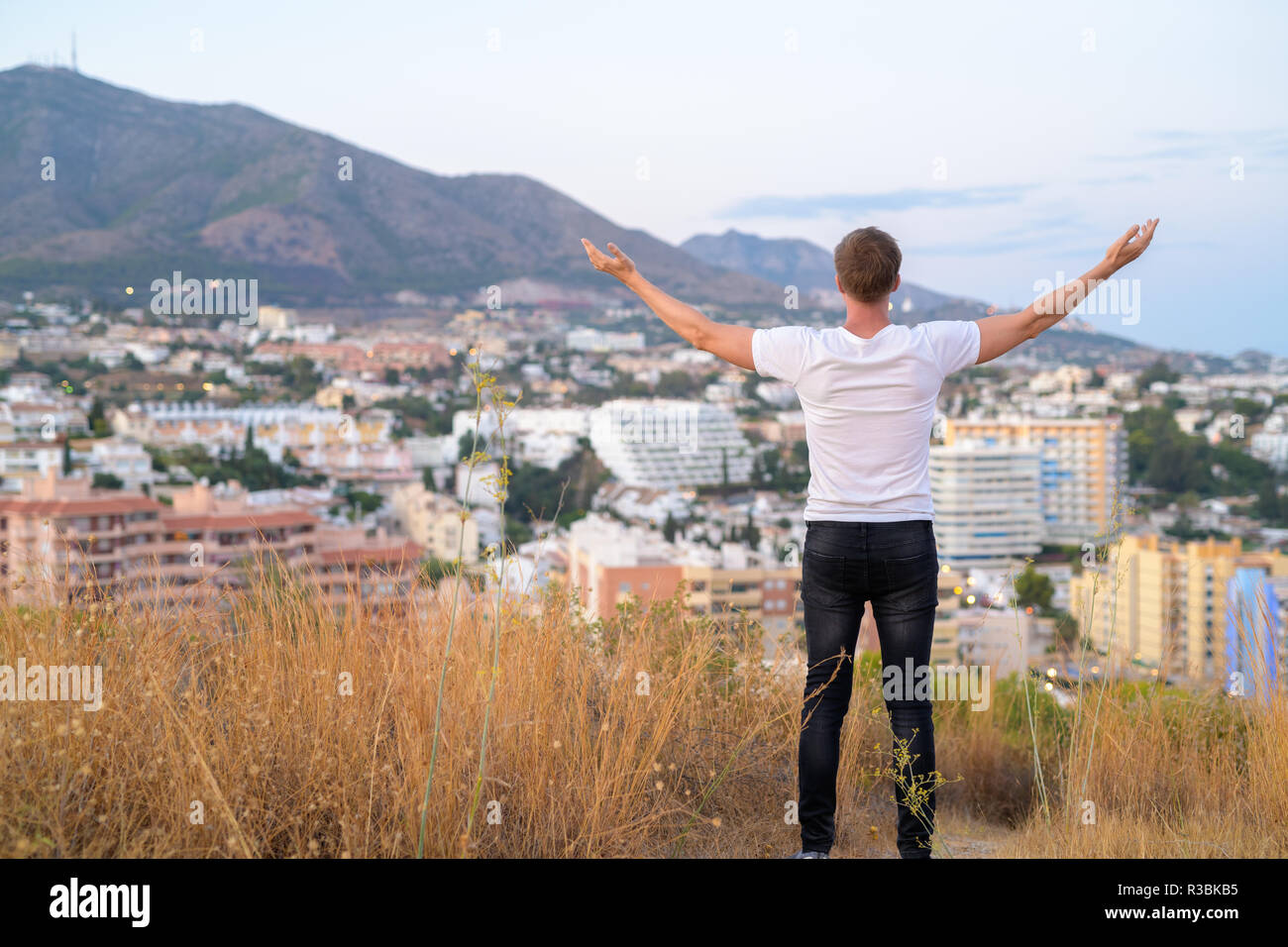 Rear View Of Young Tourist Man Standing With Arms Raised On Top Of The ...