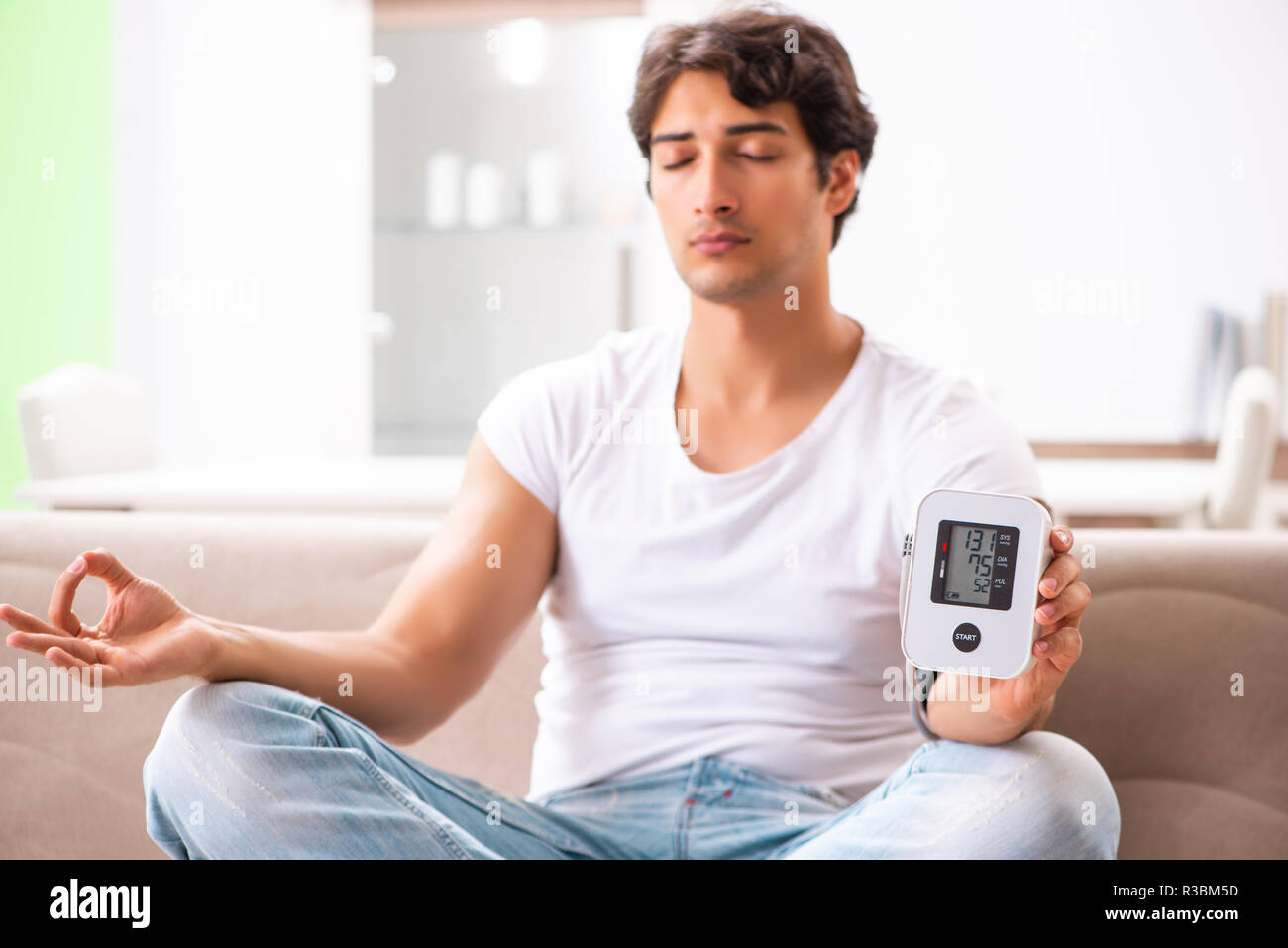 Young man measuring blood pressure at home Stock Photo - Alamy