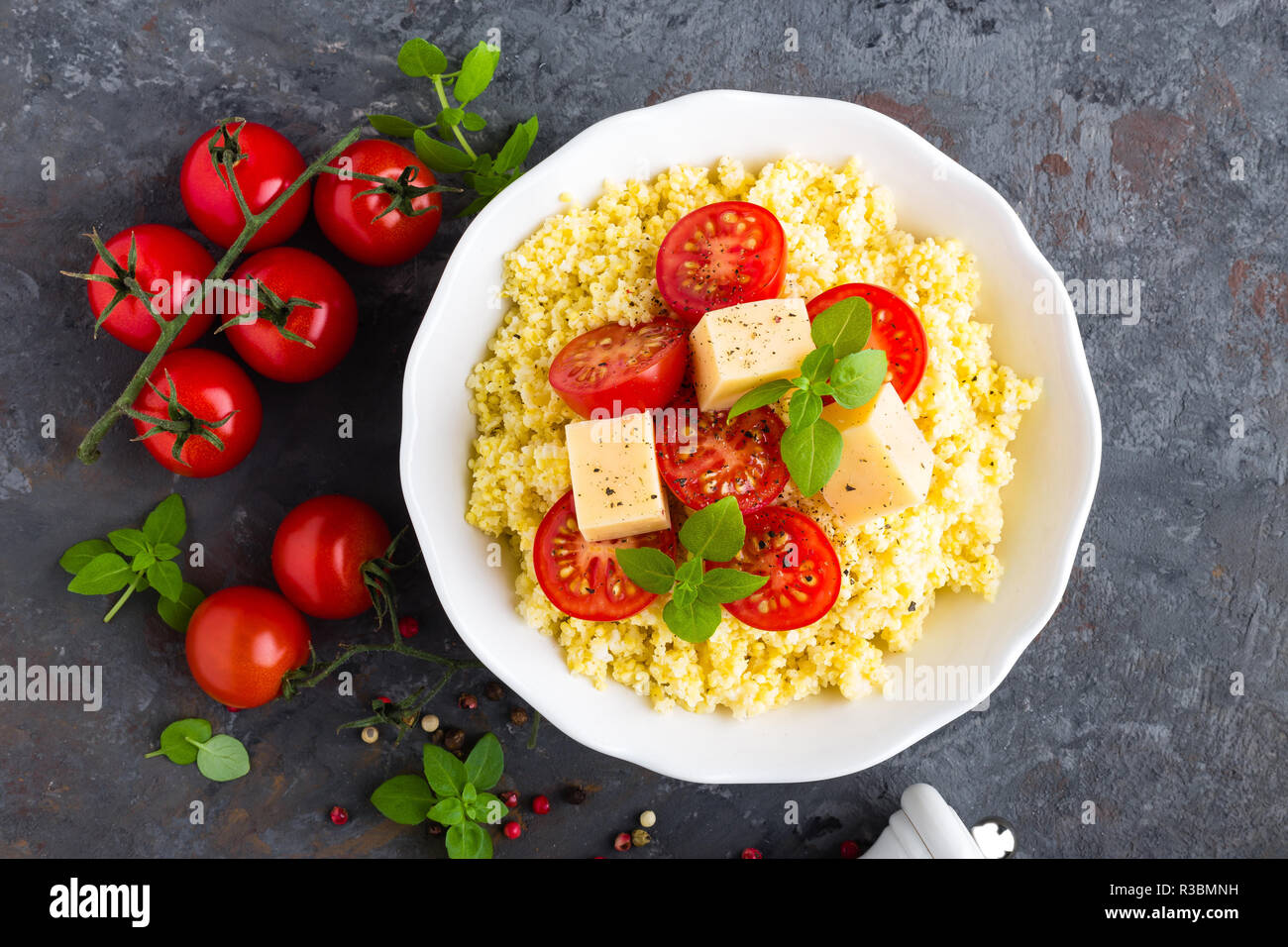 Millet porridge with tomatoes and cheese Stock Photo - Alamy