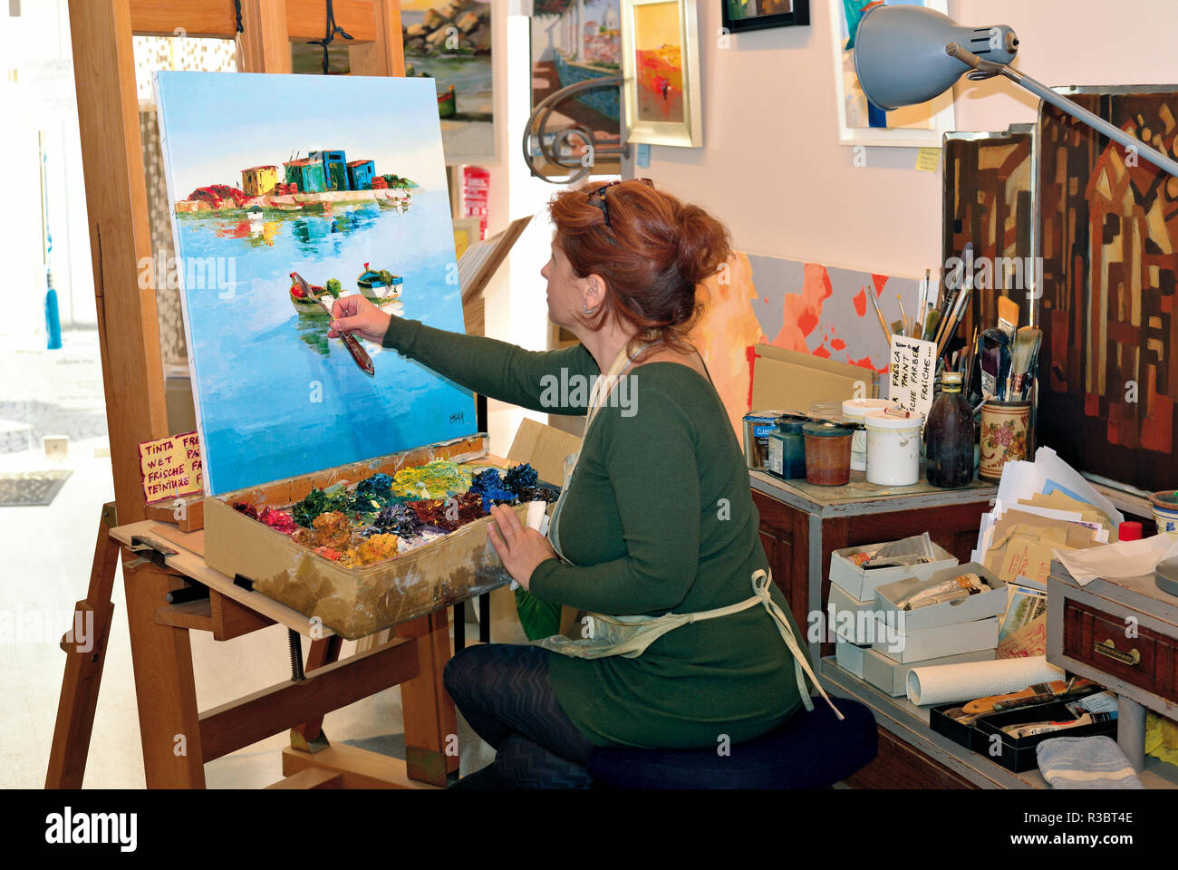 Artist Corine Thinon working on a painting in her art gallery and atelier  in Lagos Stock Photo