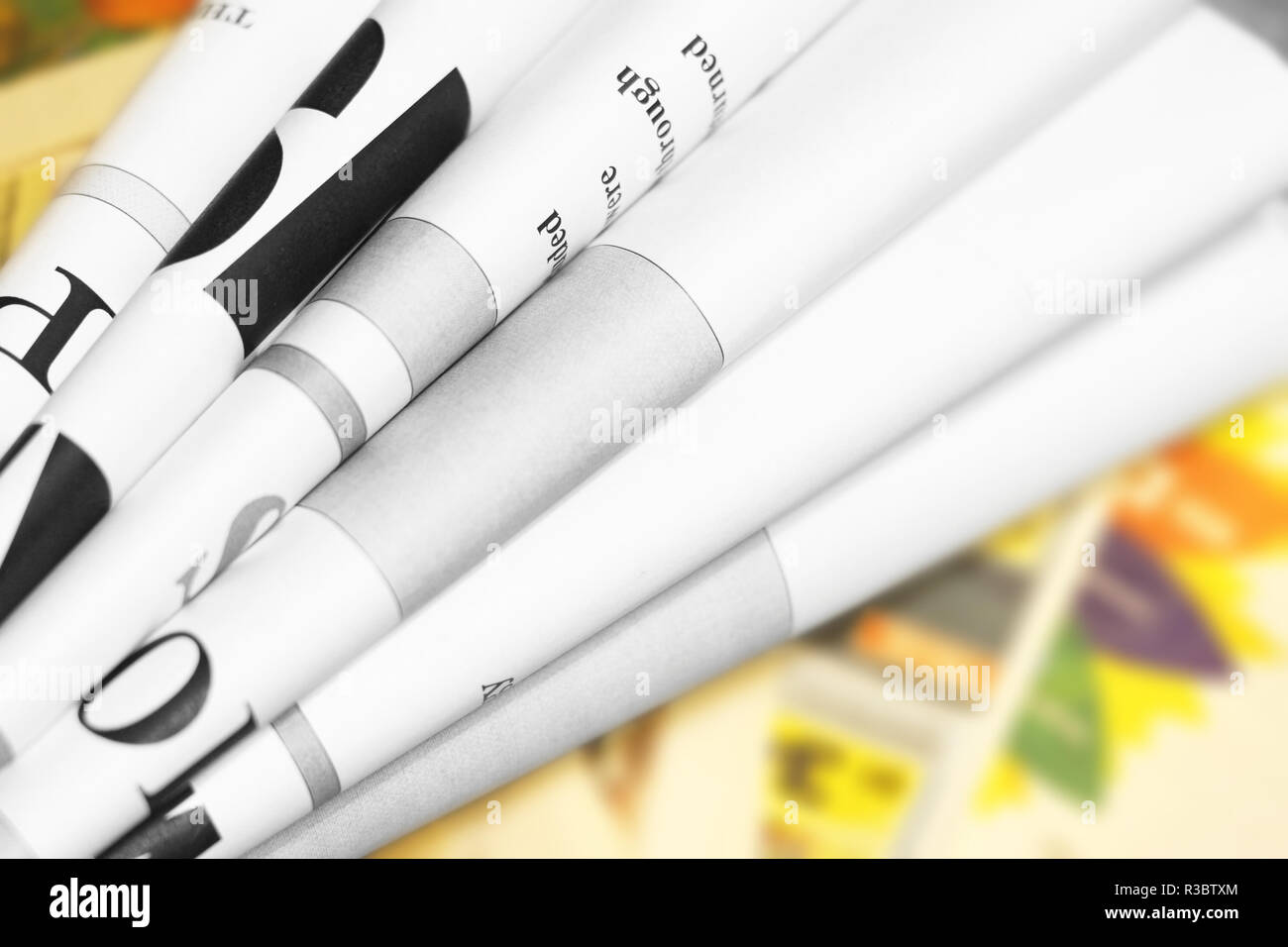 Folded newspapers with partially visible headlines and pages with articles - blurred text and photos. Papers with news, business and finance journals Stock Photo