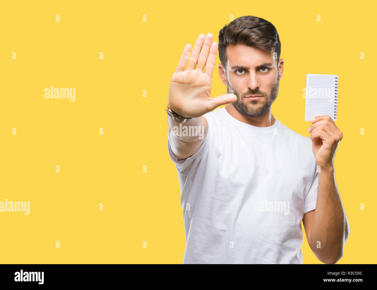 Young handsome man holding notebook over isolated background with open ...