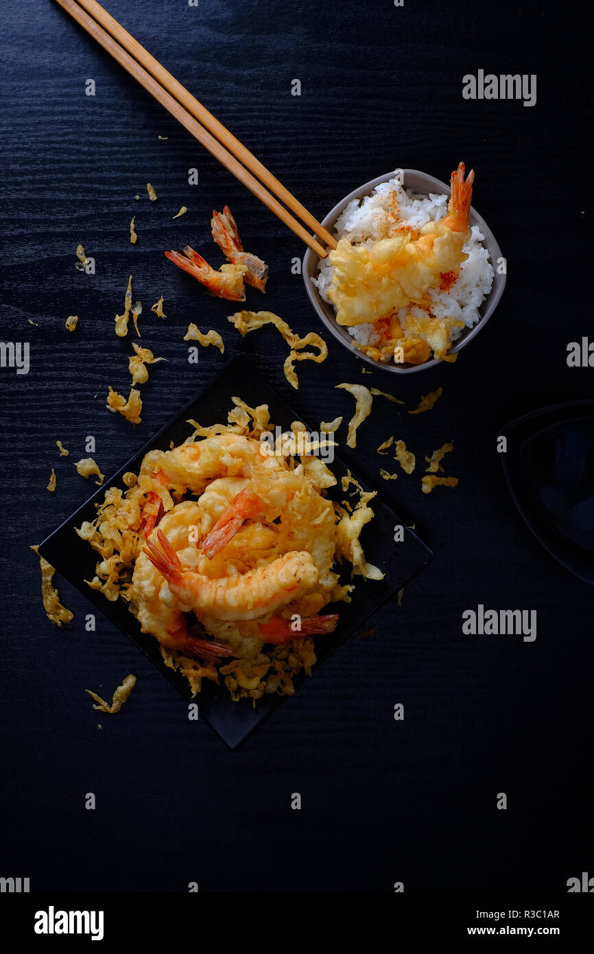 Ebi tempura shrimp on black wood and background with rice, sticks top view Stock Photo