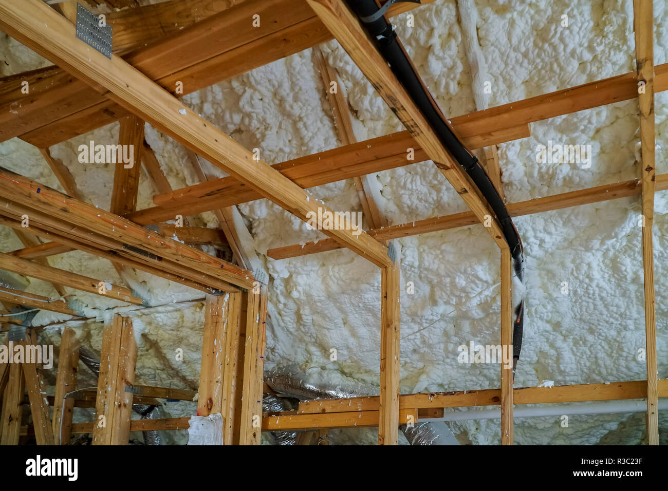 Installing thermal foam polyurea insulation under the roof wool panels and wooden planks Stock Photo