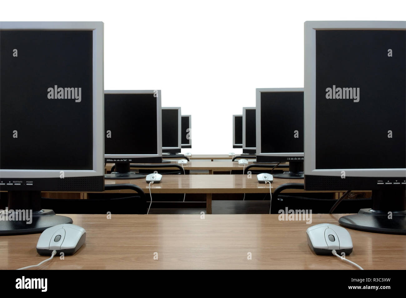 Row of computer monitors in classroom. White background, isolated Stock