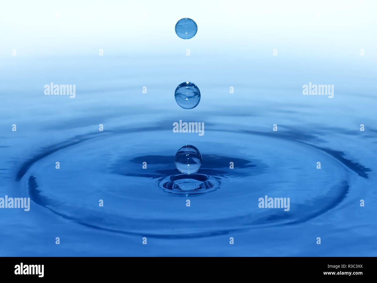 Raindrops falling on surface of water Stock Photo