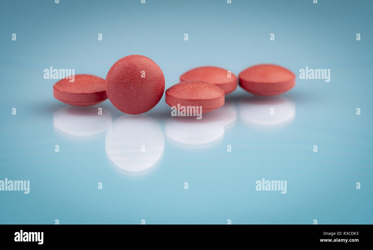 Selective focus on orange round tablets with shadow on gradient background. Pharmaceutical industry. Pharmacy products. Vitamins and supplements conce Stock Photo