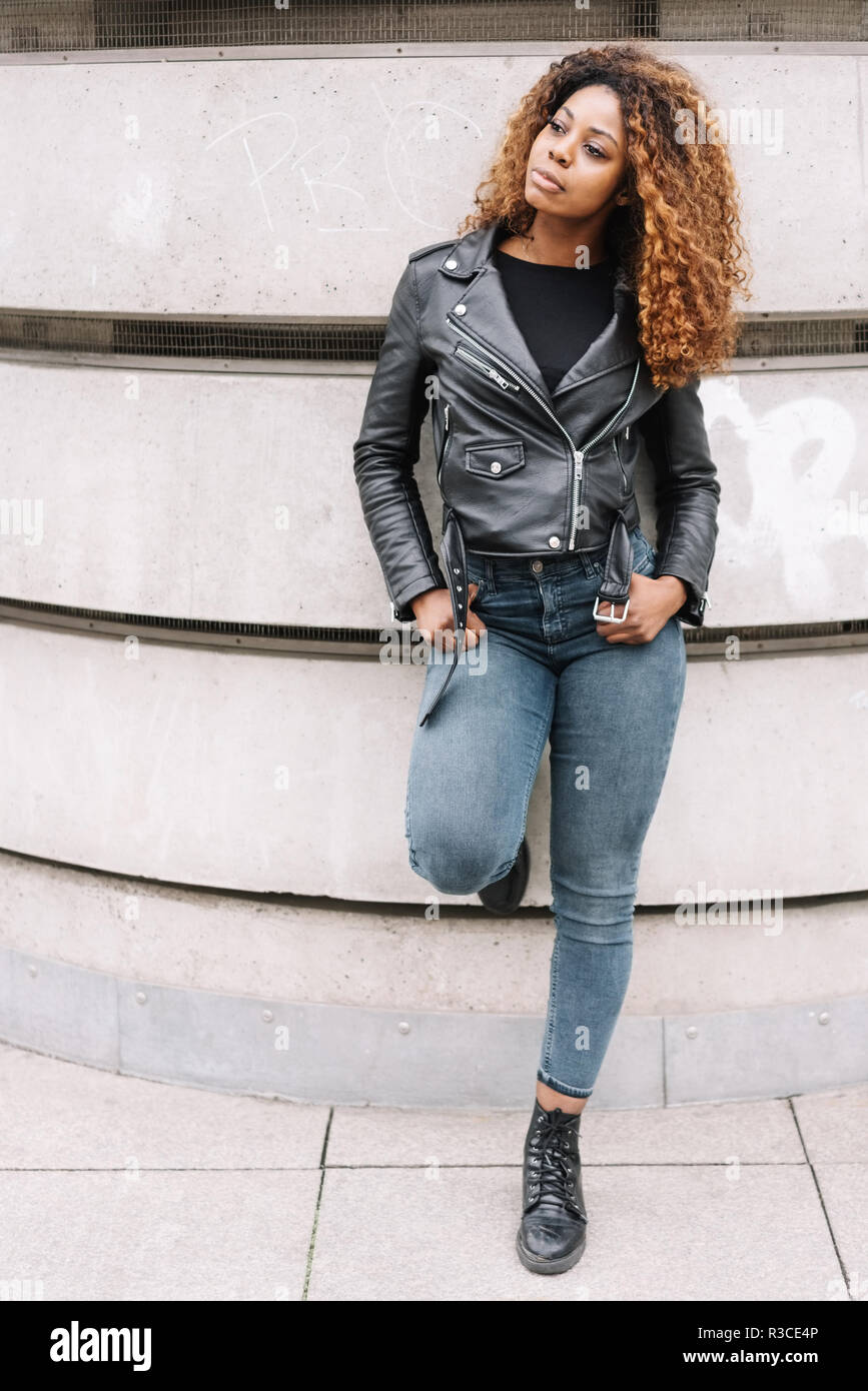 Street portrait of black woman in leather jacket and jeans Stock Photo -