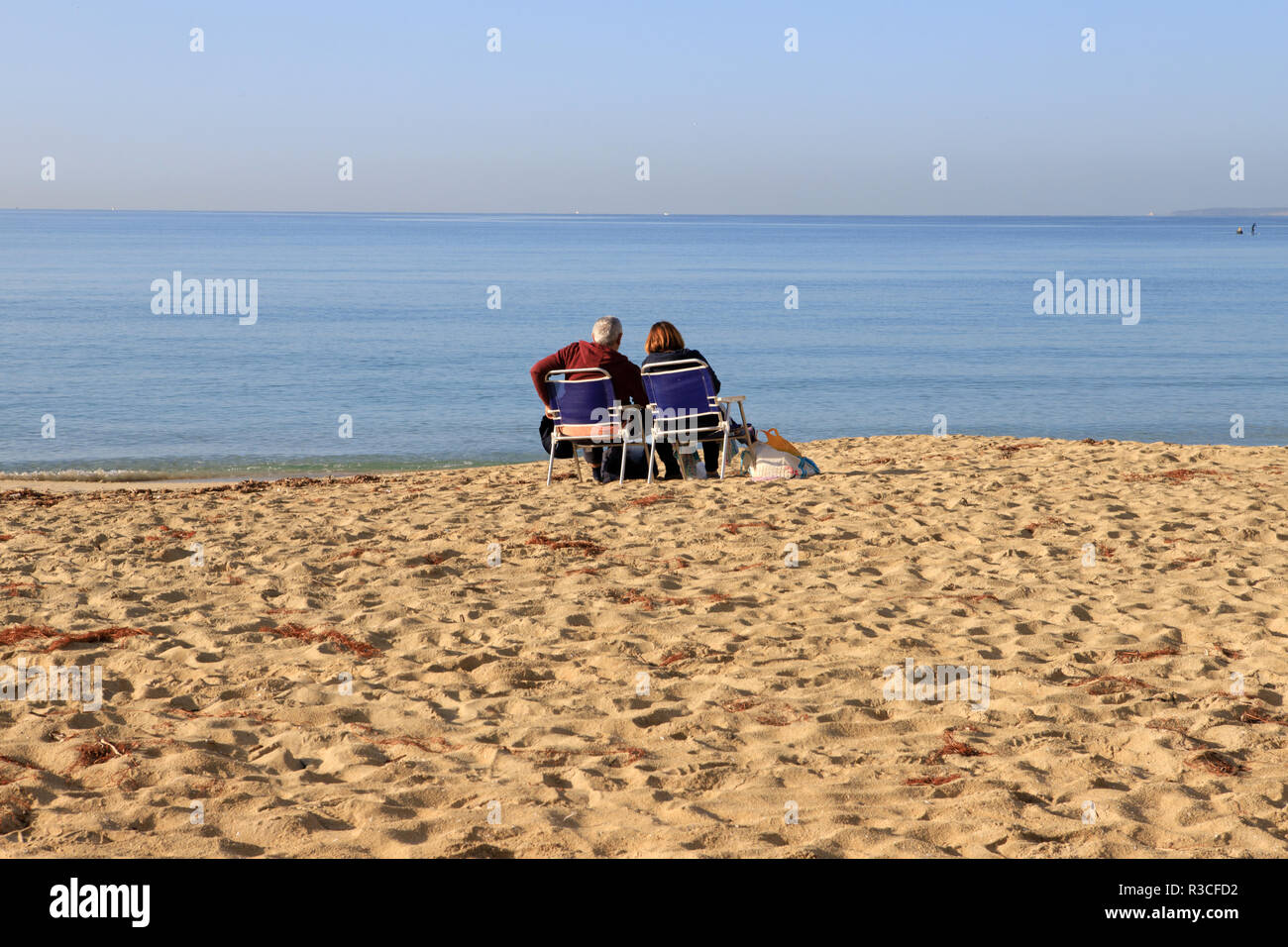 Couple sitting on promenade beach, Mallorca beach, PLaya de Palma, winter time Stock Photo