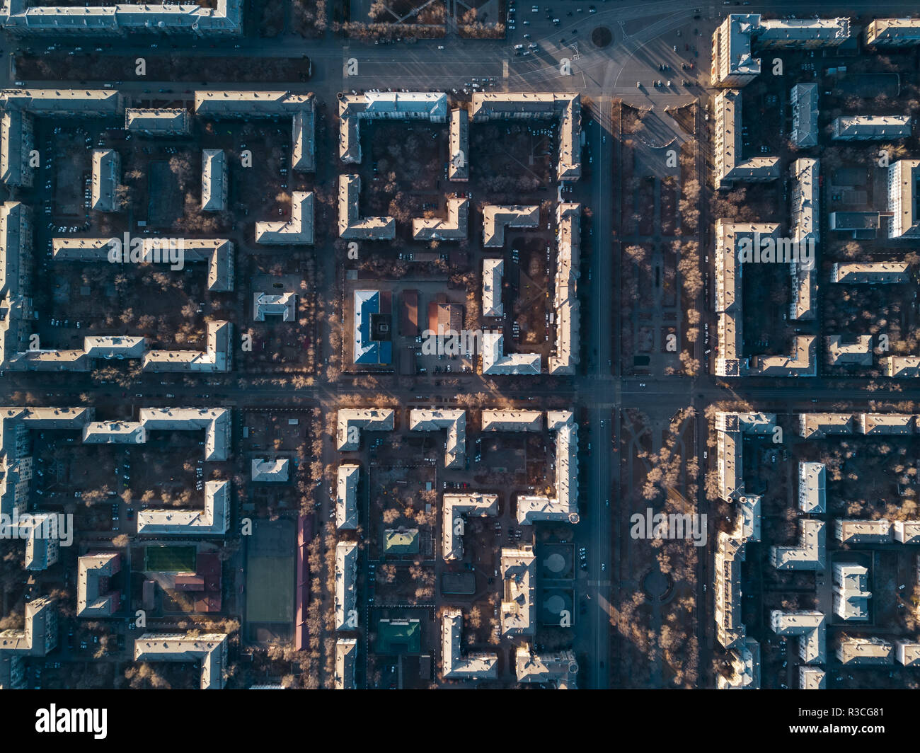 Aerial view of cityscape; top down drone shot; smooth rows of houses and streets with square in center; architectural ensembles, complexes with garden Stock Photo