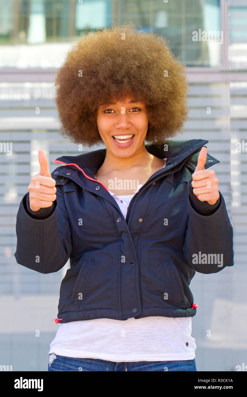 young woman with afro hairstyle and a thumbs up Stock Photo - Alamy