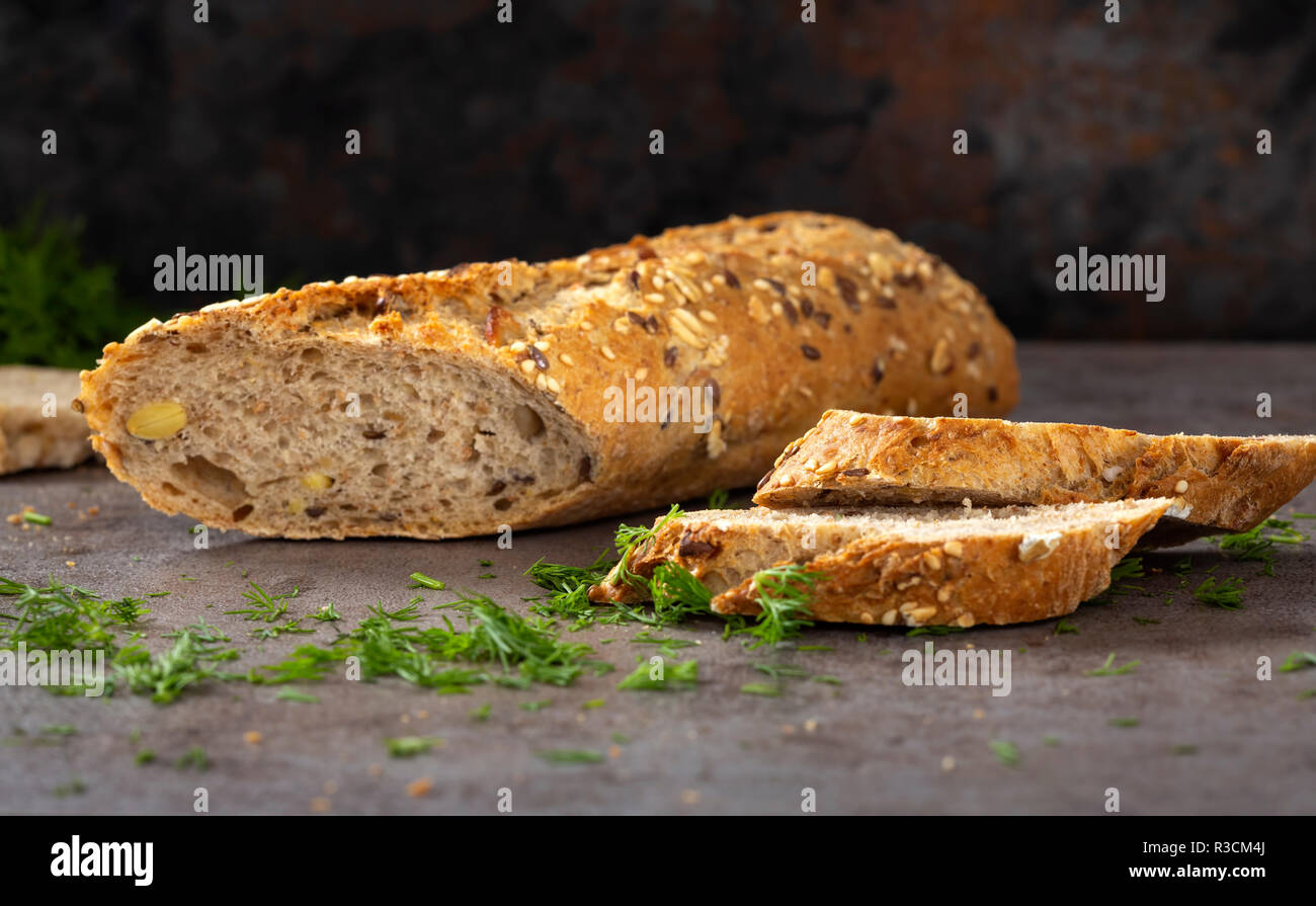 Bread with different seeds ( pumpkin, poppy, flax, sunflower, sesame, millet ) decorated with chopped green dill Stock Photo