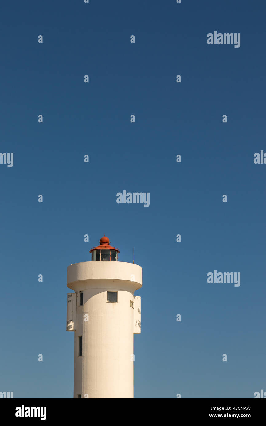 The top of a lighthouse isolated against a clear blue sky image with copy space in portrait format Stock Photo