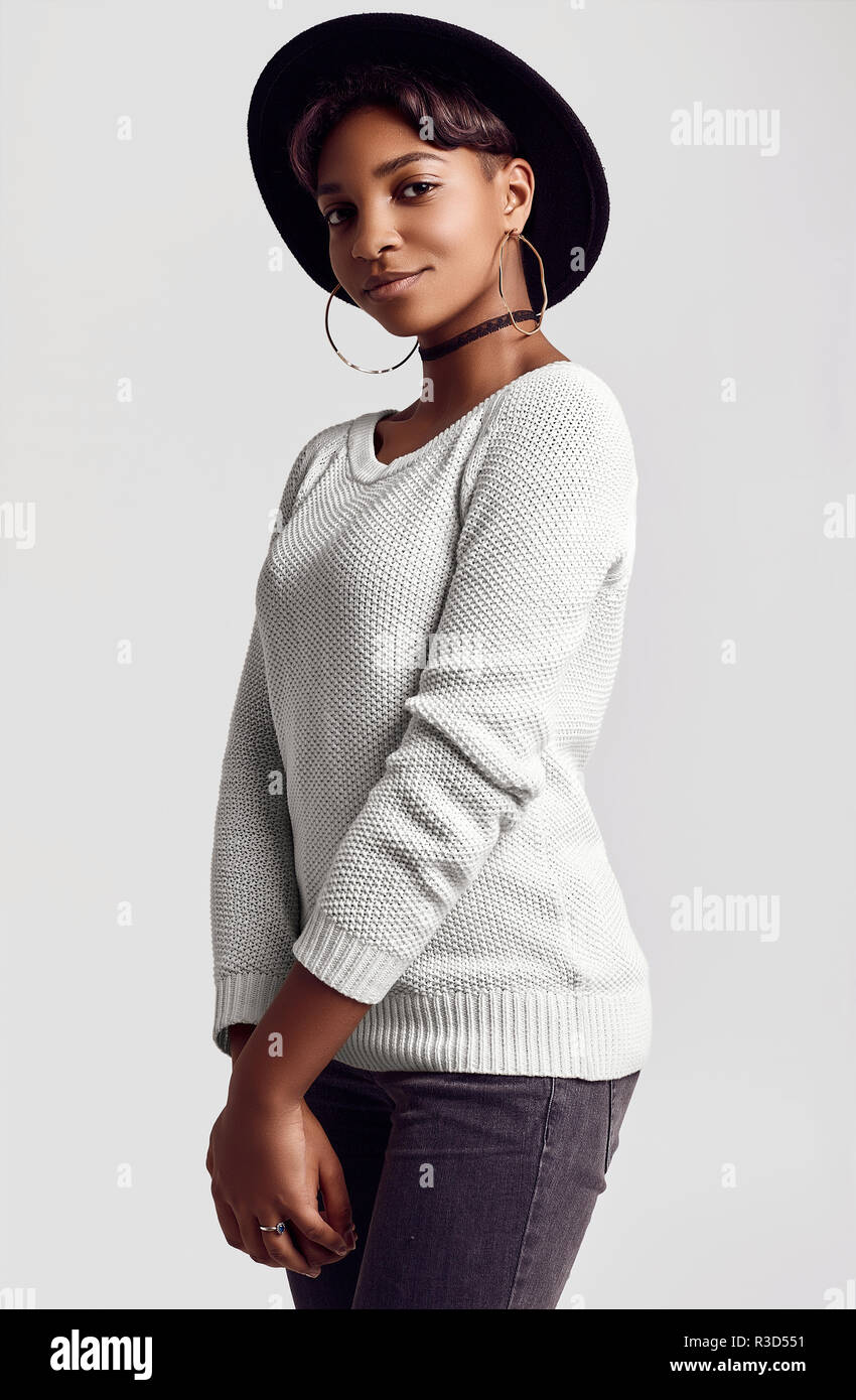 Portrait of young beautiful hipster black girl with short hair smiling in  white sweater and fashion hat isolated on white background. Studio shoot  Stock Photo - Alamy