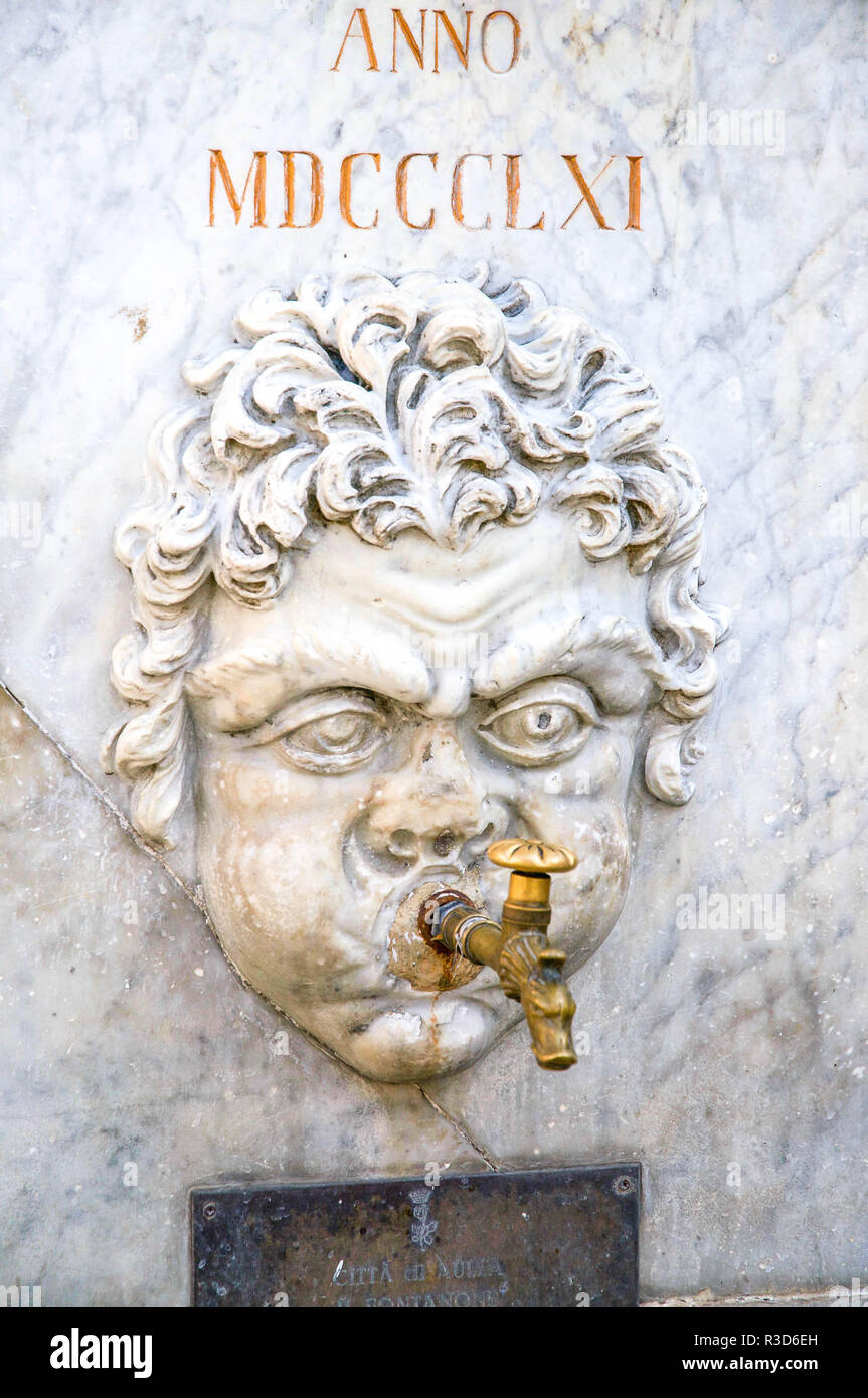 Roman-style Sculpted Head as an Outdoor Public Water Tap in a piazza in Aulla, Tuscany, Italy. Stock Photo