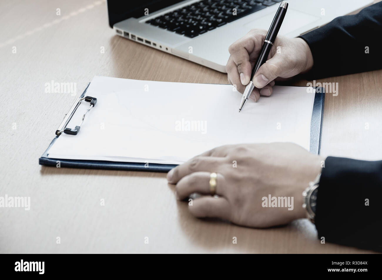 Businessman at office desk signing a contract form. Stock Photo