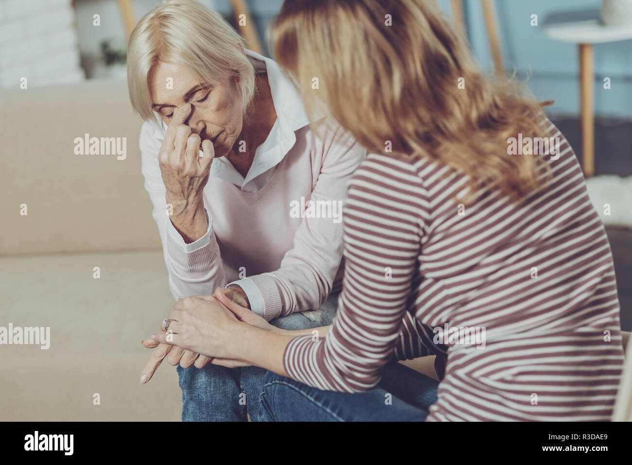 Fatigue. Moody elderly woman touching her nose and complaining about