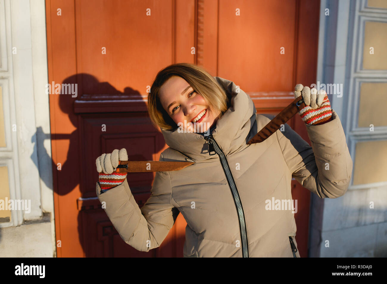 Playful stylish girl enjoying winter walk on a frosty sunny day. Concept of smile and good mood. Stock Photo