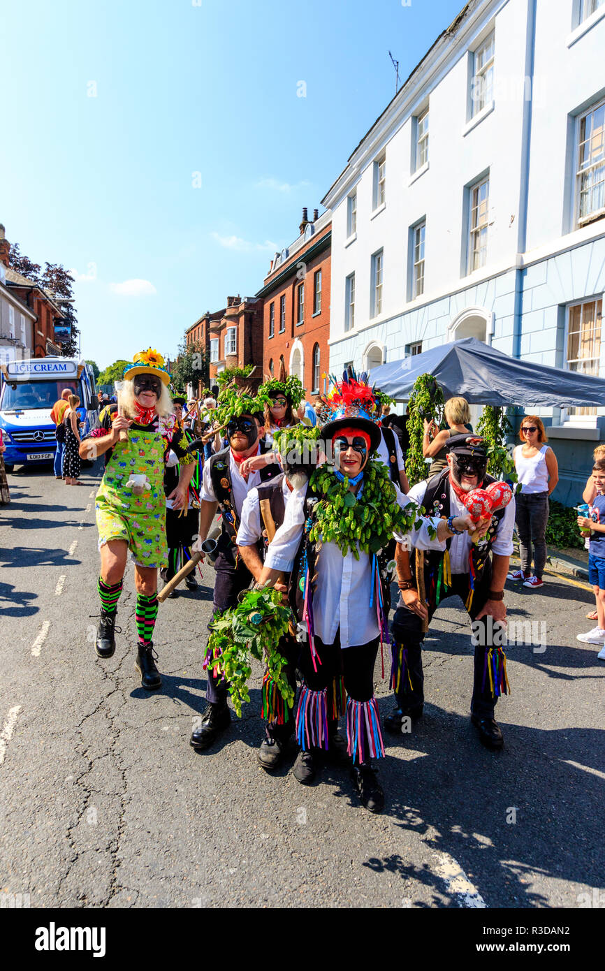 Faversham hop festival. Parade, Dead Horse and the broomdashers Morris side, with blacked faces, walking towards viewer along street in bright sunshin Stock Photo