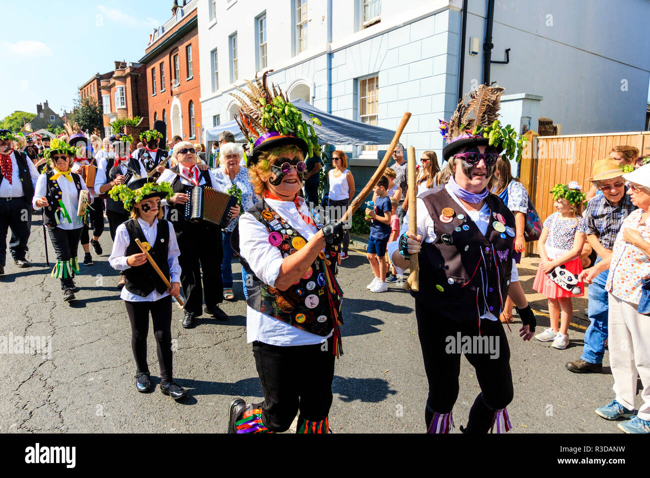 Faversham hop festival. Parade, Dead Horse and the broomdashers Morris side, with blacked faces, walking towards viewer along street in bright sunshin Stock Photo