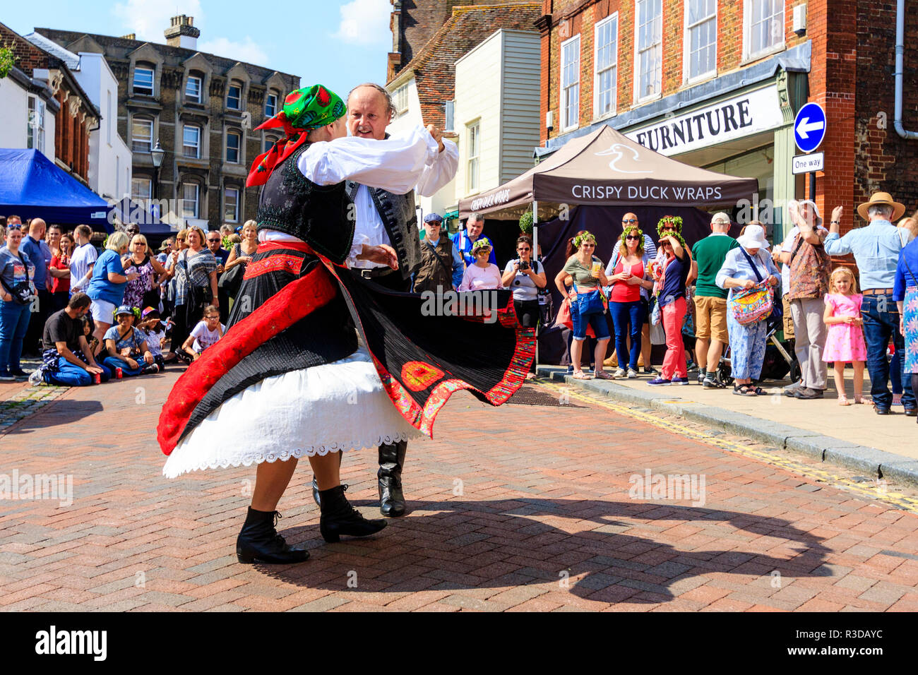 Faversham Hop Festival 2018, senior Hungarian man and woman in traditional costume dancing waltz style in front of audience in town street. Stock Photo