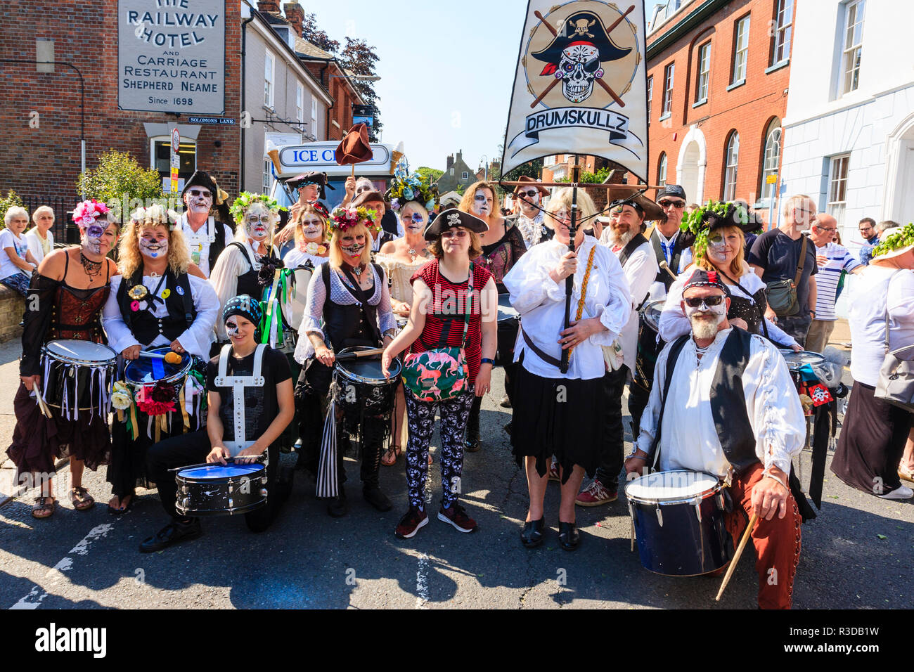 Faversham hop festival. Group shot of the Drumskulls drummers group. Smiling posing, one holds group banner, most faces painted horror pirate style. Stock Photo