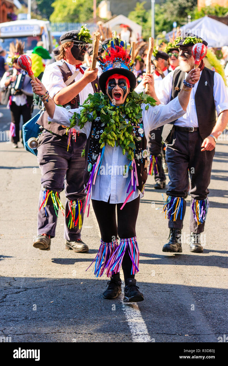 Faversham hop festival parade, Dead Horse and the broomdashers Morris side, with blacked faces, walking towards viewer along street in bright sunshine Stock Photo