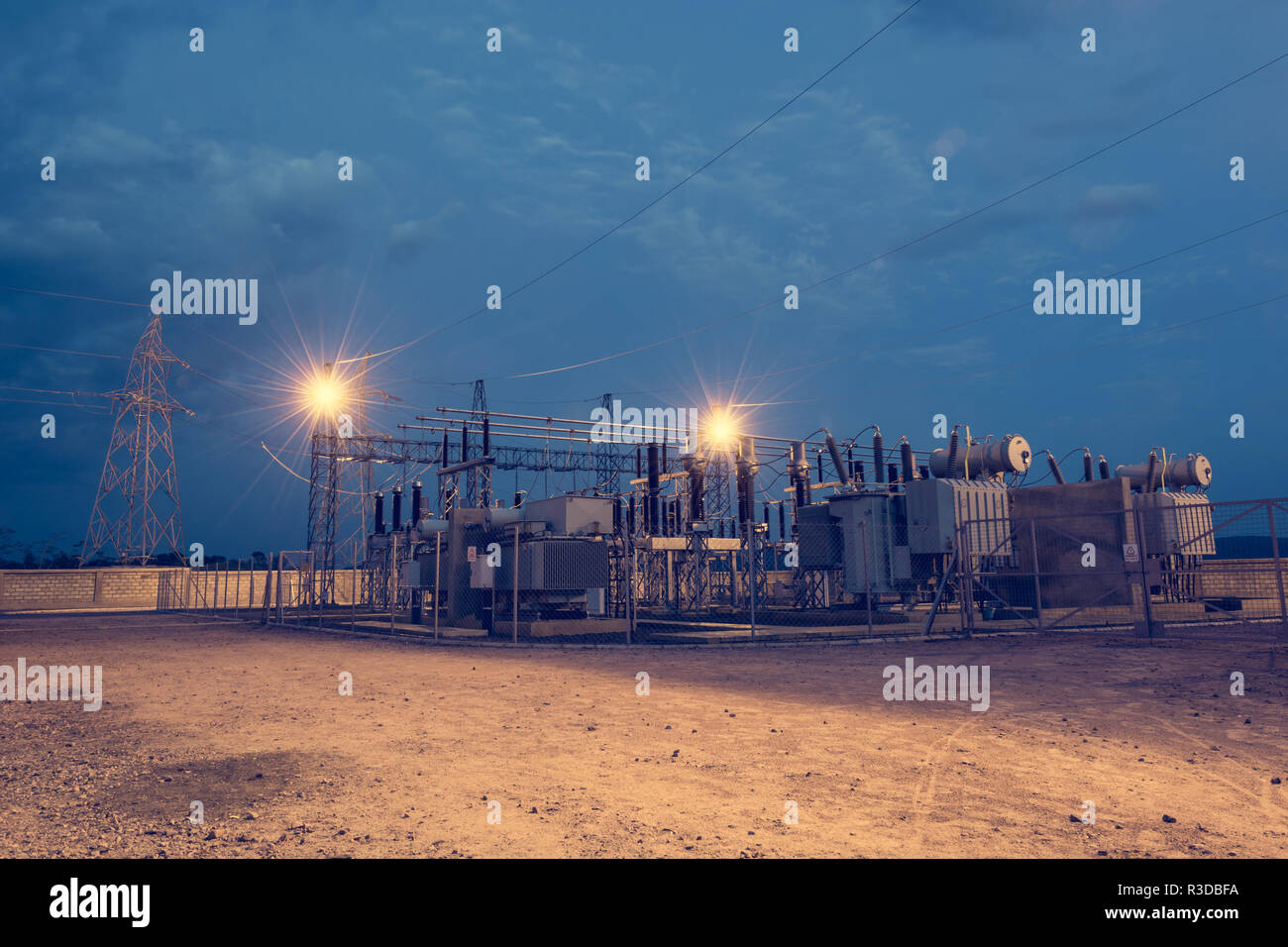 Electrical power substation illuminated by lights at night. Deliver