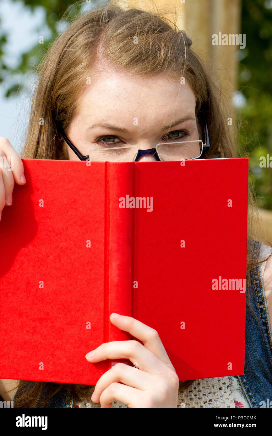 young woman with book in nature Stock Photo