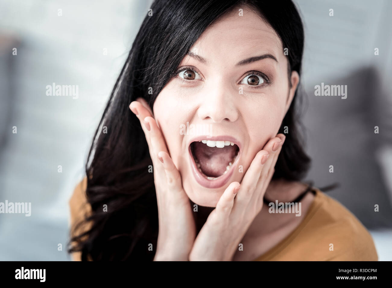 I am crying. Delighted raising her eyebrows while looking at