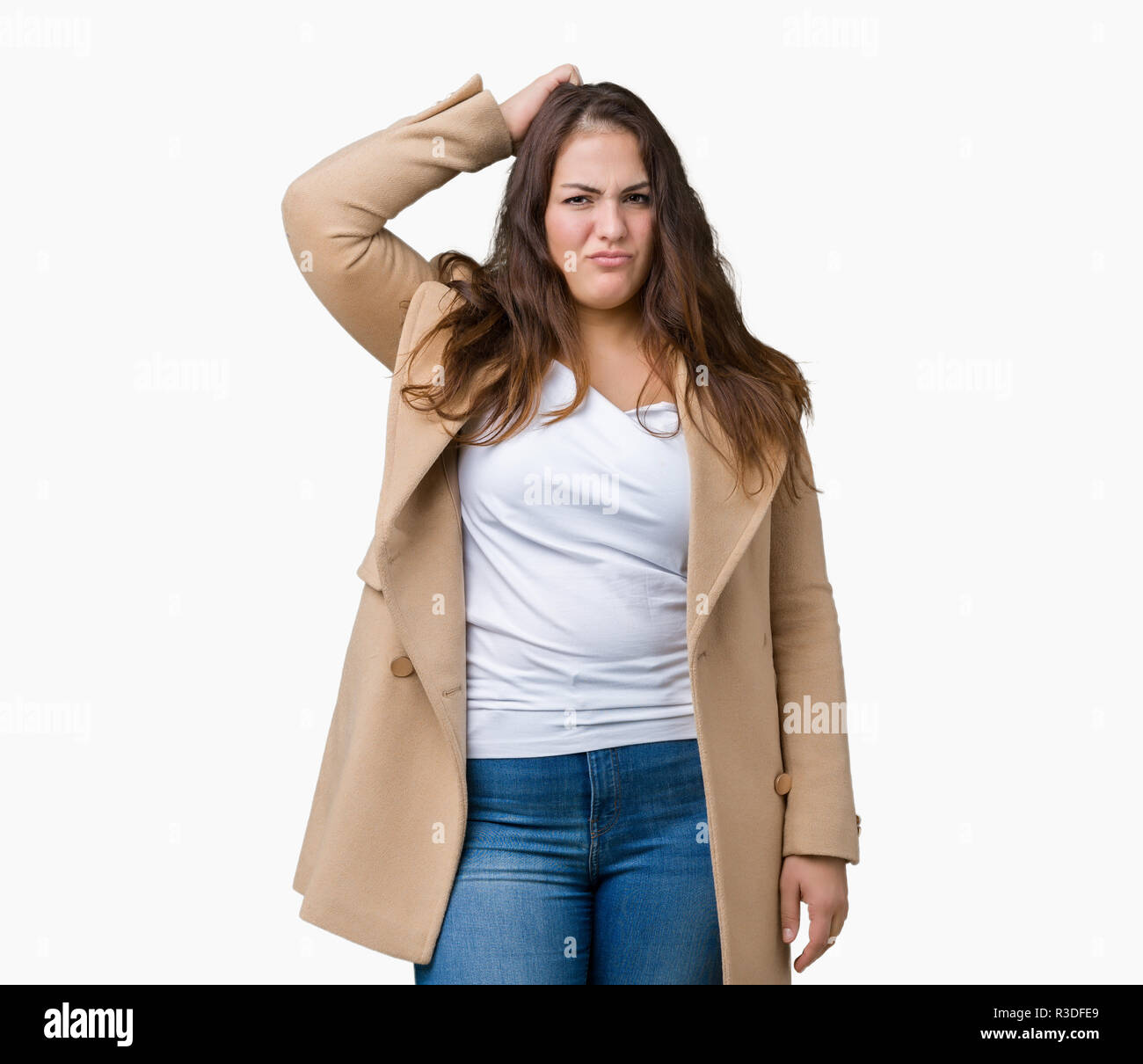 Beautiful plus size young woman wearing winter coat over isolated background confuse and wonder about question. Uncertain with doubt, thinking with ha Stock Photo