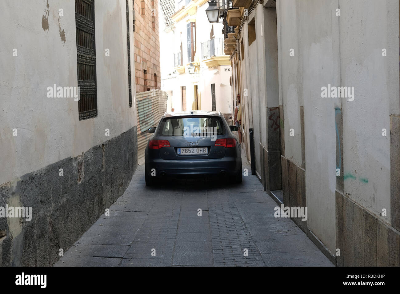 A car squeezes down a narrow street in Spain Stock Photo