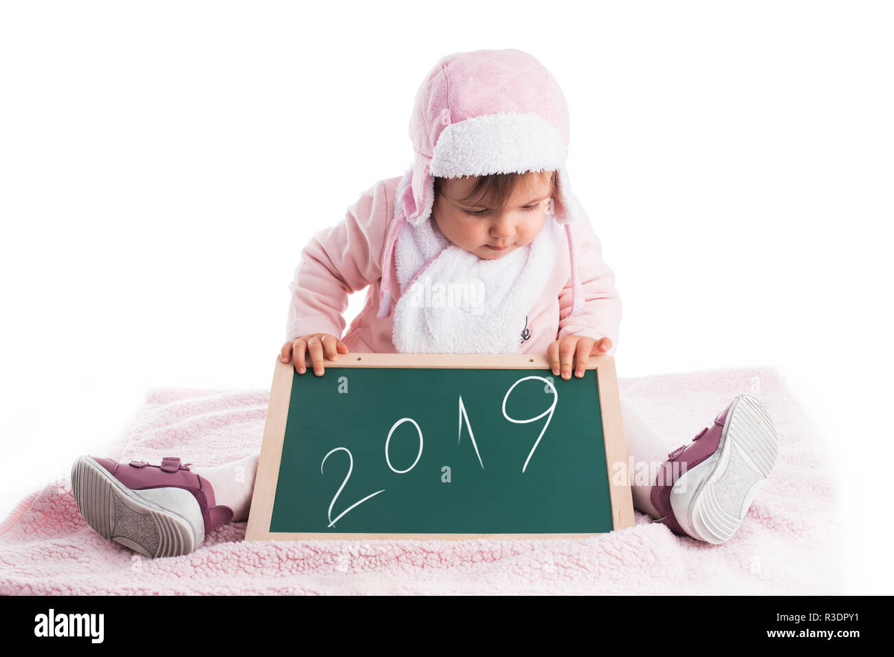 Child baby girl holding wooden blackboard  with text 2019 year isolated on white. Stock Photo
