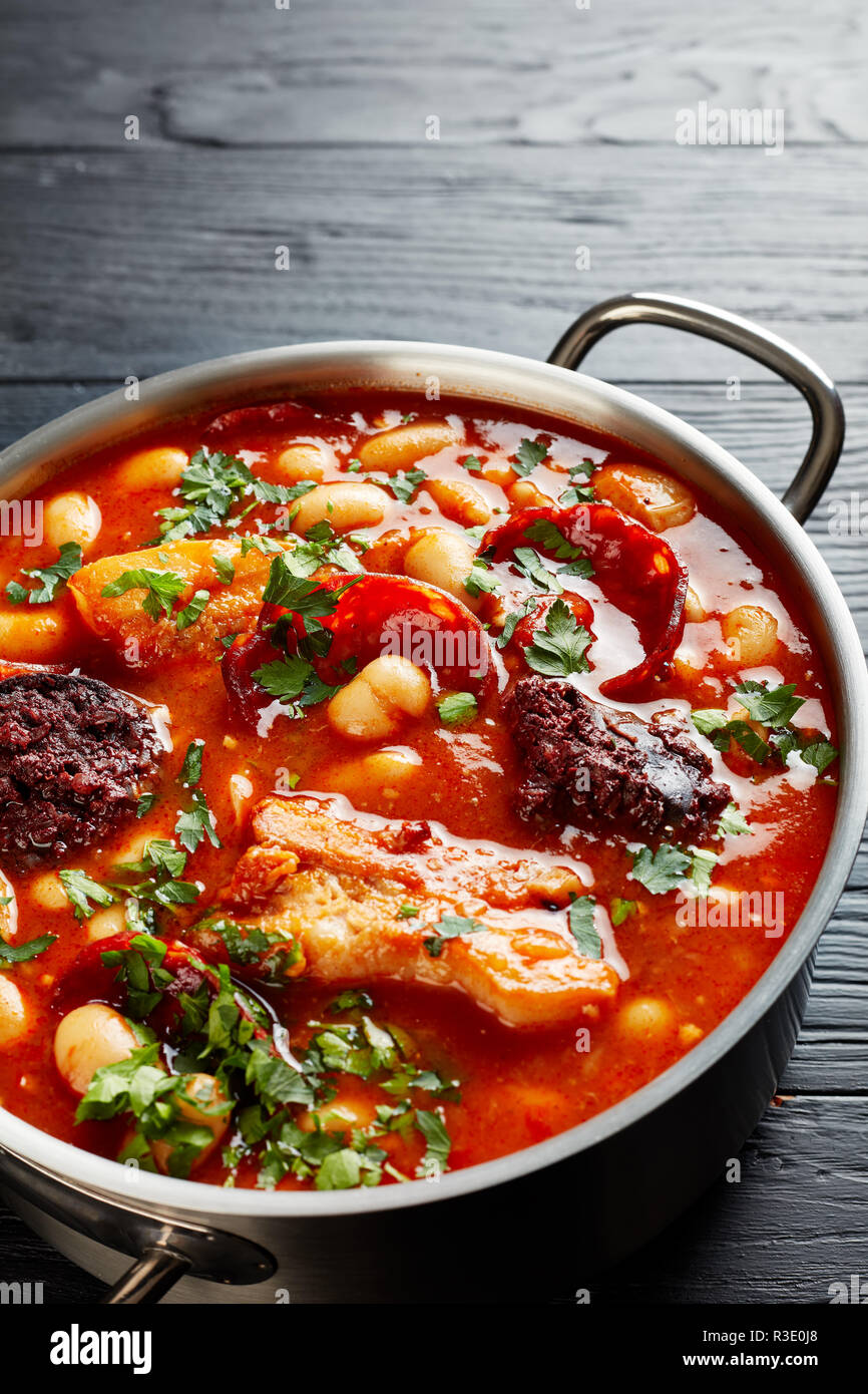 Bean Stew with chorizo, bacon and blood sausages in a metal casserole