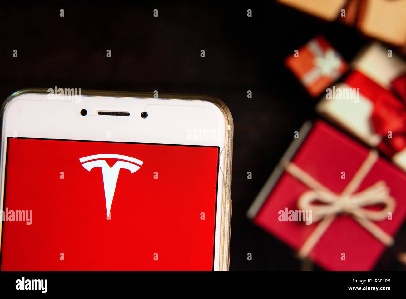 American electric car manufacturing  company Telsa logo is seen on an Android mobile device with a Christmas wrapped gifts in the background. Stock Photo