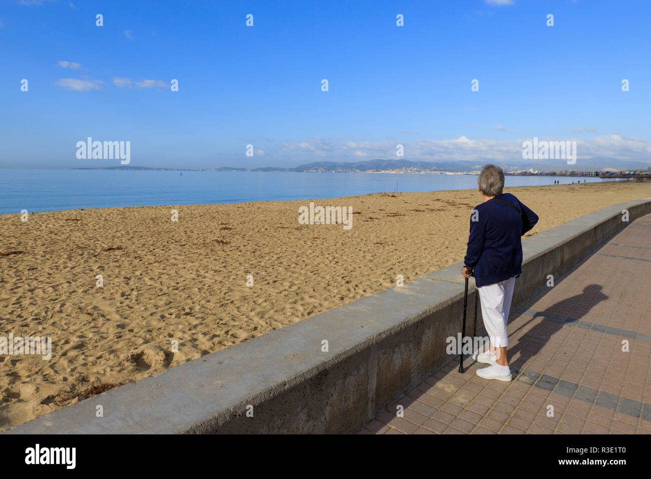 Senior woman looking out on promenade, Mallorca beach, PLaya de Palma, winter time Stock Photo