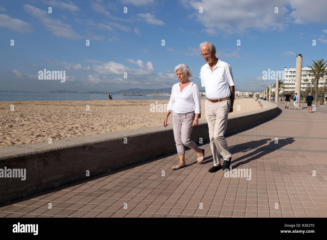 Couple of elderly walking on promenade beach, Mallorca beach, PLaya de Palma, winter time Stock Photo