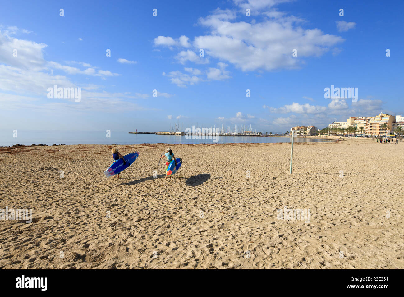women preparing to surf with padel table, Mallorca beach, PLaya de Palma, winter time Stock Photo