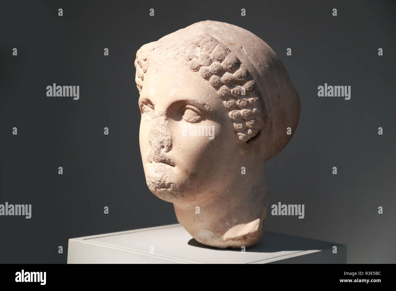 Marble head from a statue of a woman wearing a sakkos (cap) at the