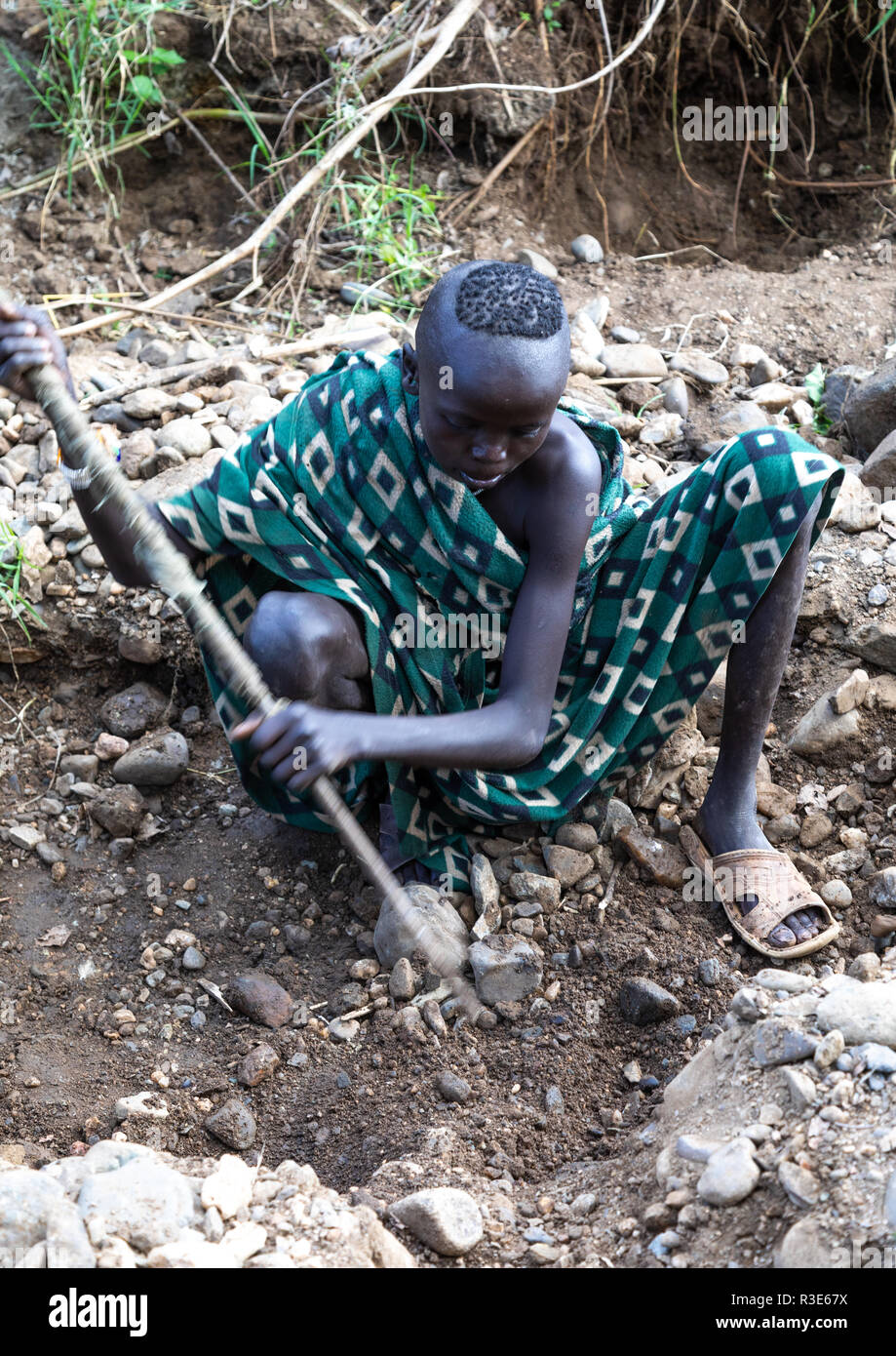 Suri tribe girls doing gold panning in a river, Omo valley, Kibish, Ethiopia Stock Photo