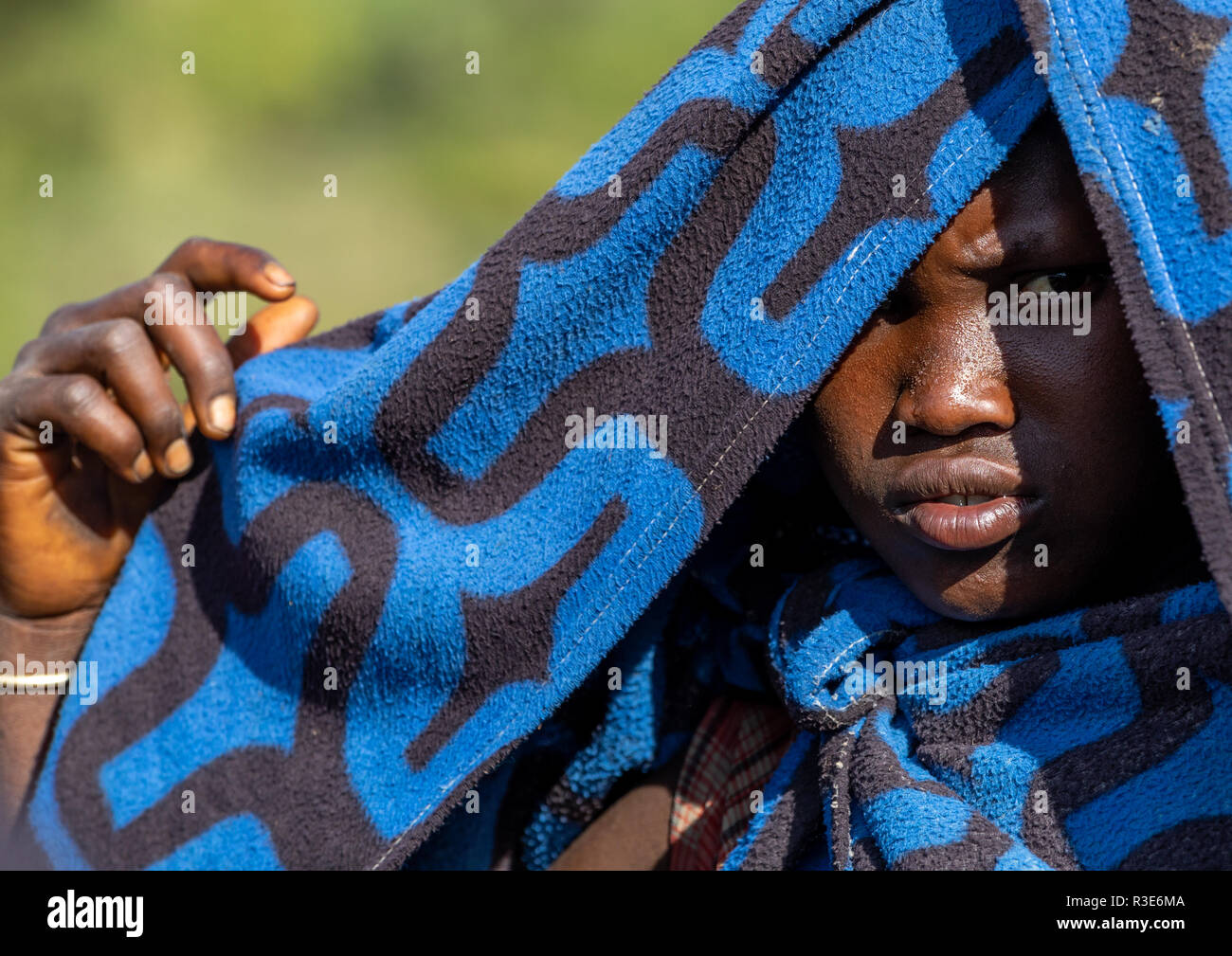 Suri tribe girl protecting her head from the sun with her blanket, Omo valley, Kibish, Ethiopia Stock Photo