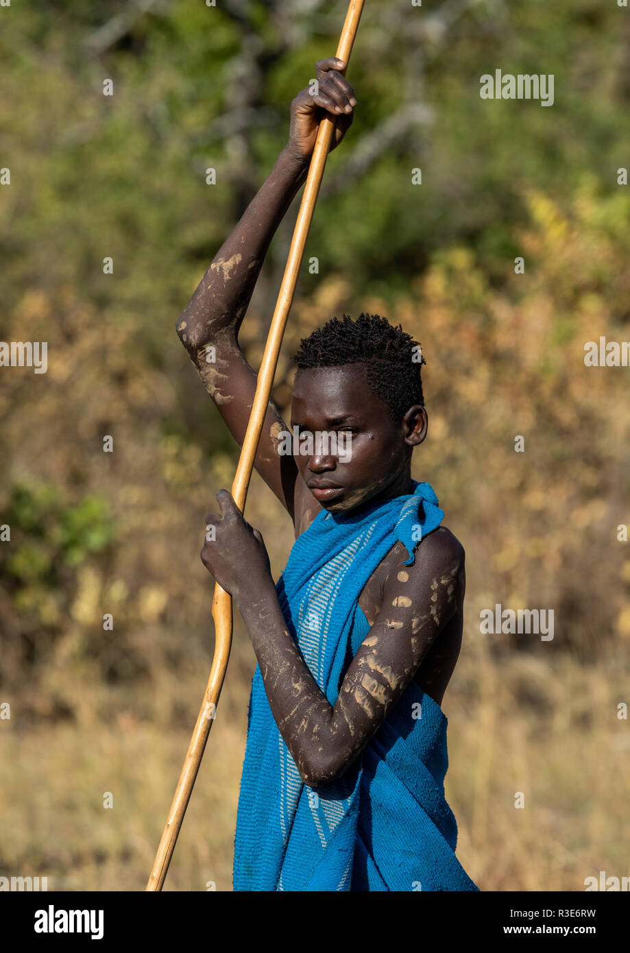 Suri tribe boy with a stick during a donga ritual, Omo valley, Kibish, Ethiopia Stock Photo