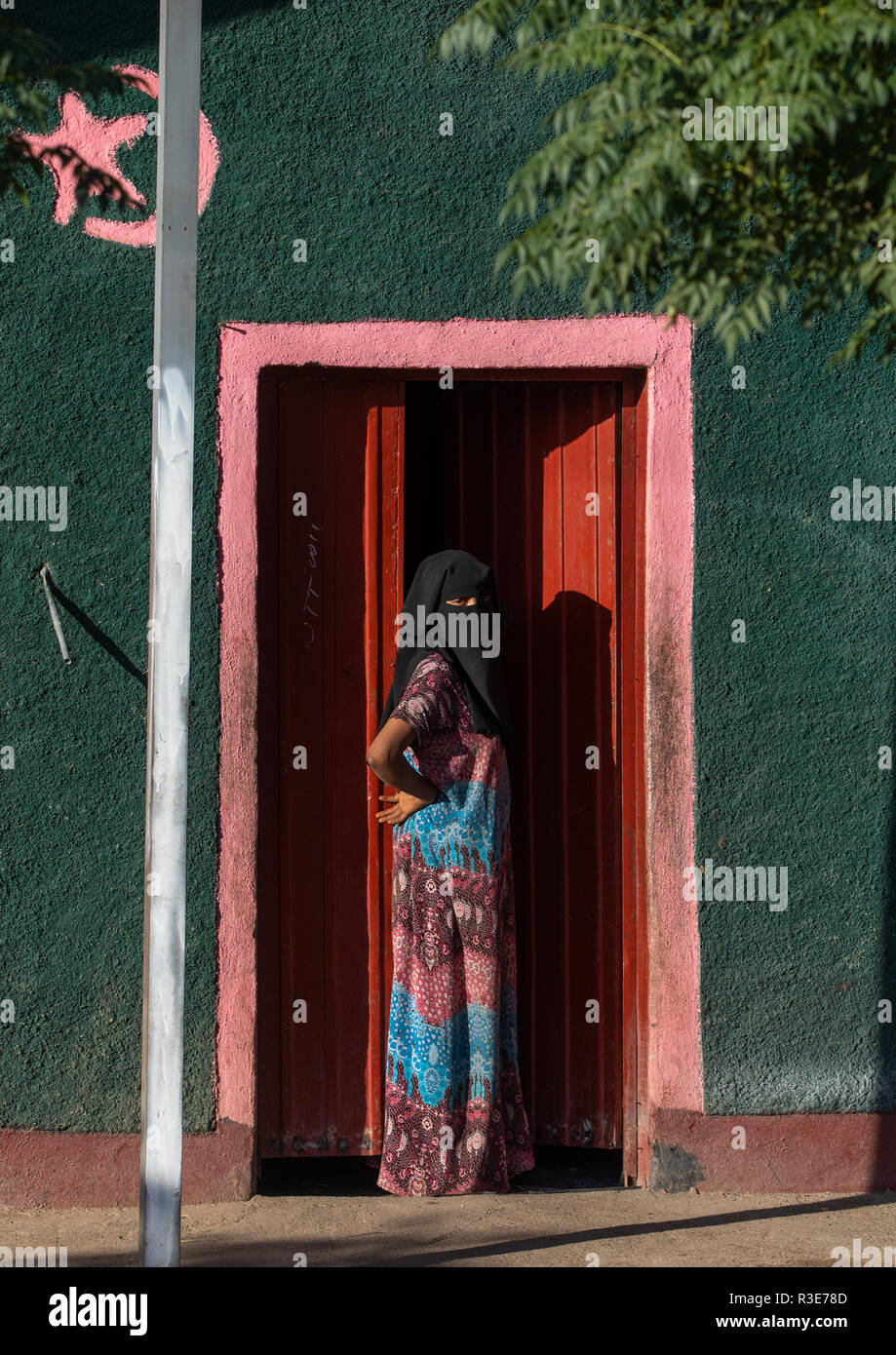 Oromo woman wearing a burqa at the entrance of her house, Amhara region, Senbete, Ethiopia Stock Photo