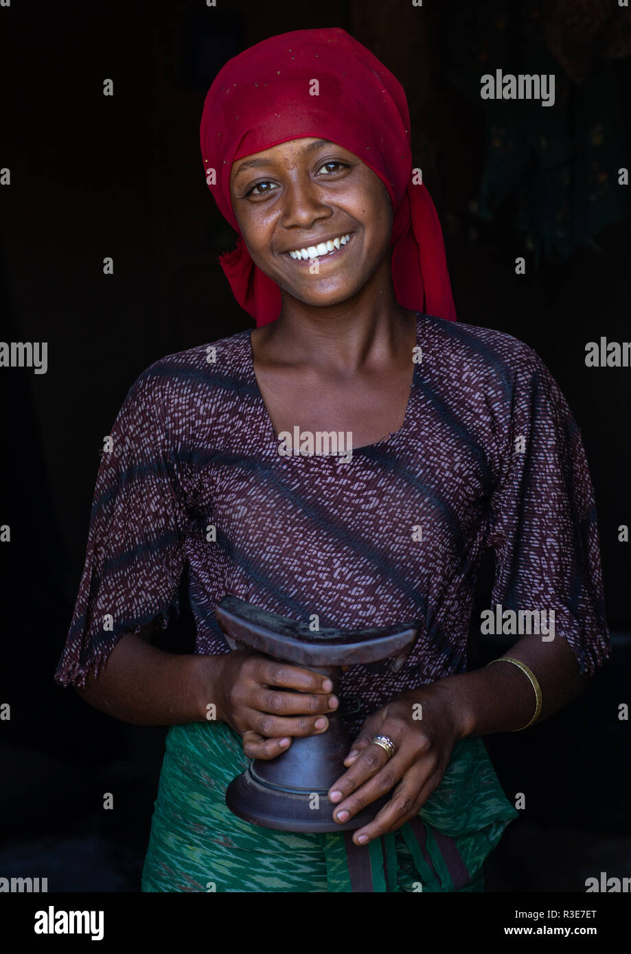 Portrait of a smiling raya tribe girl holding a wooden pillow, Afar Region, Chifra, Ethiopia Stock Photo