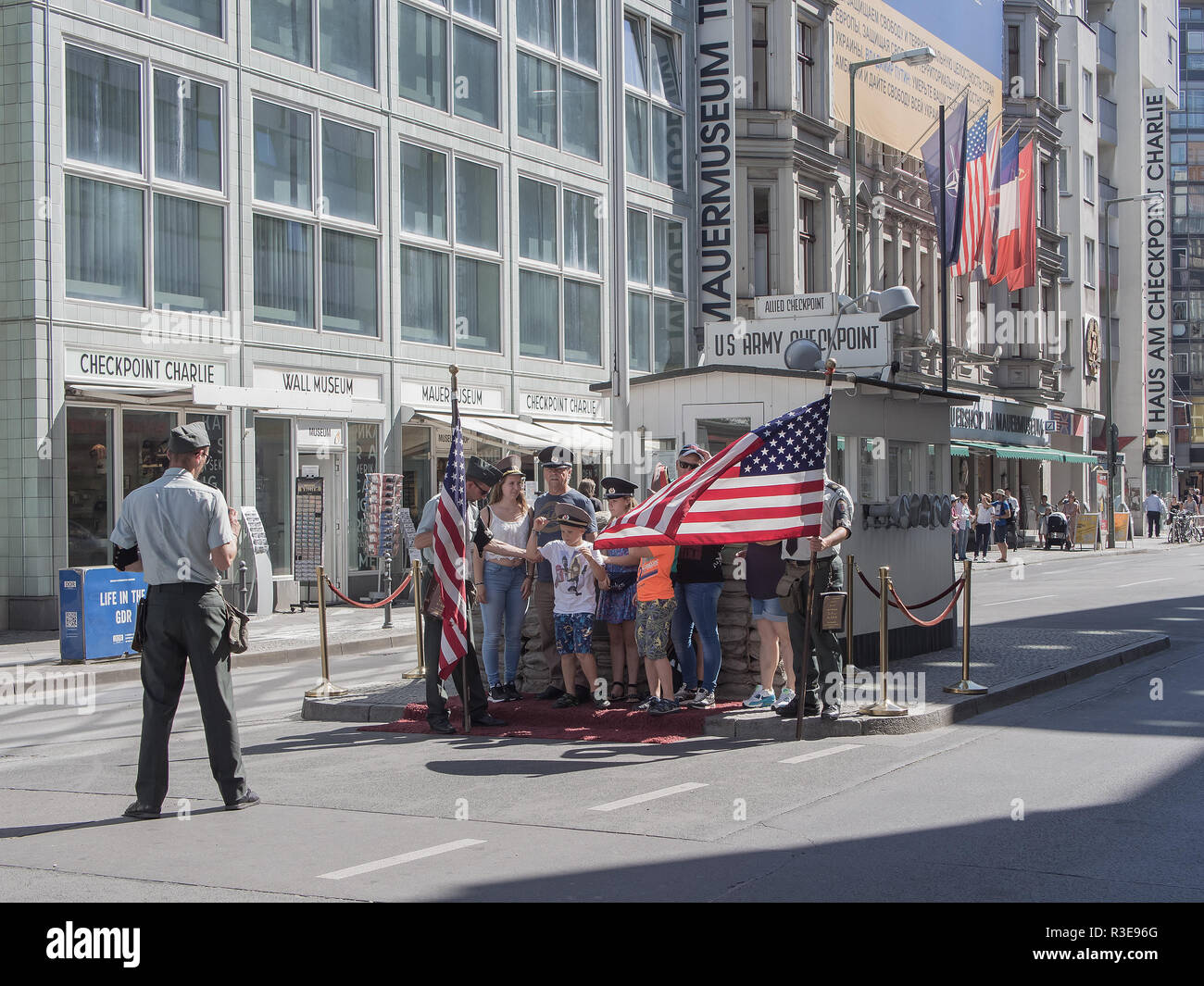 BERLIN, GERMANY - AUGUST 25, 2016: Tourists Posing At Historic US Army Checkpoint Charlie In Berlin, Germany Stock Photo