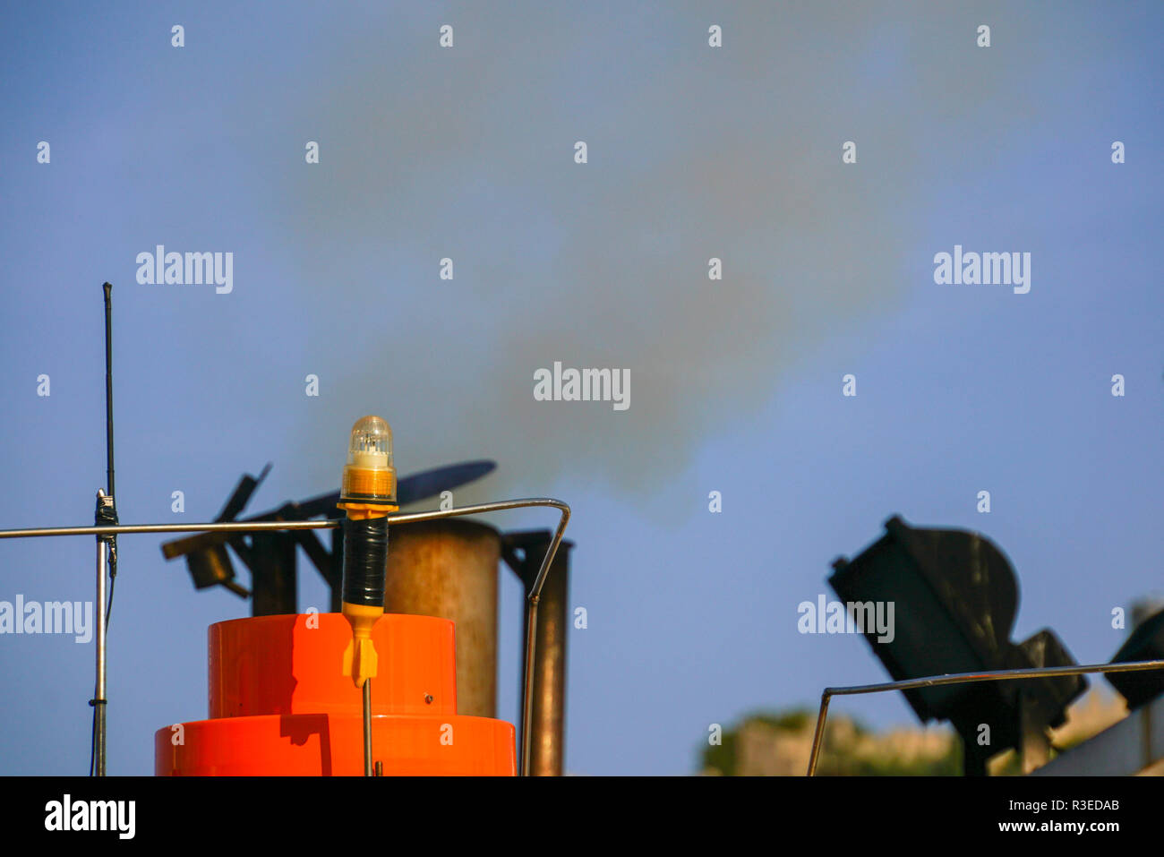 exhaust pipe emitting smoke and fumes from an old maritime diesel engine on a fishing boat Stock Photo