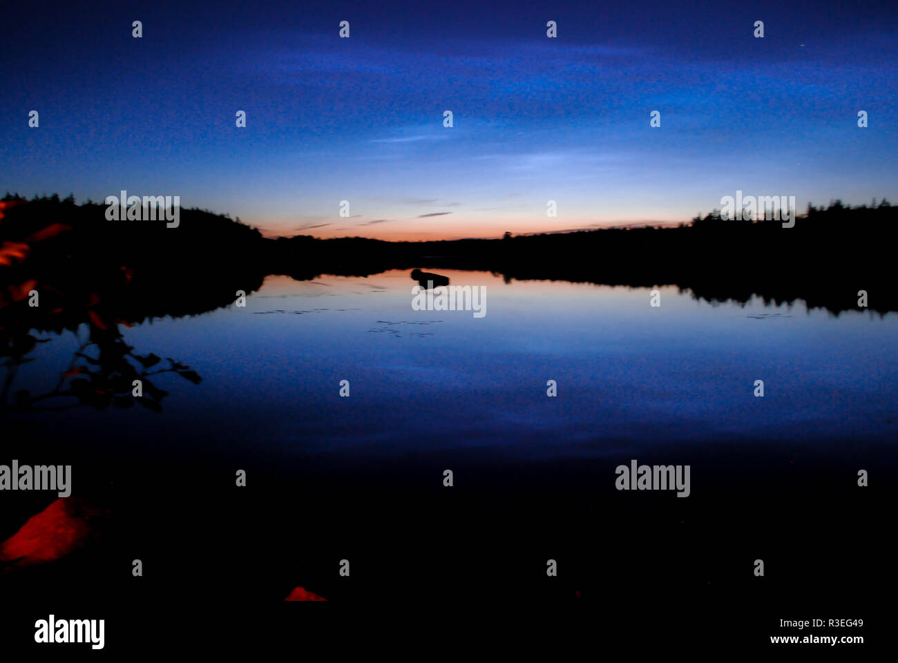 Blue hour over a lake with reflection in Skåne, southern Sweden Stock Photo